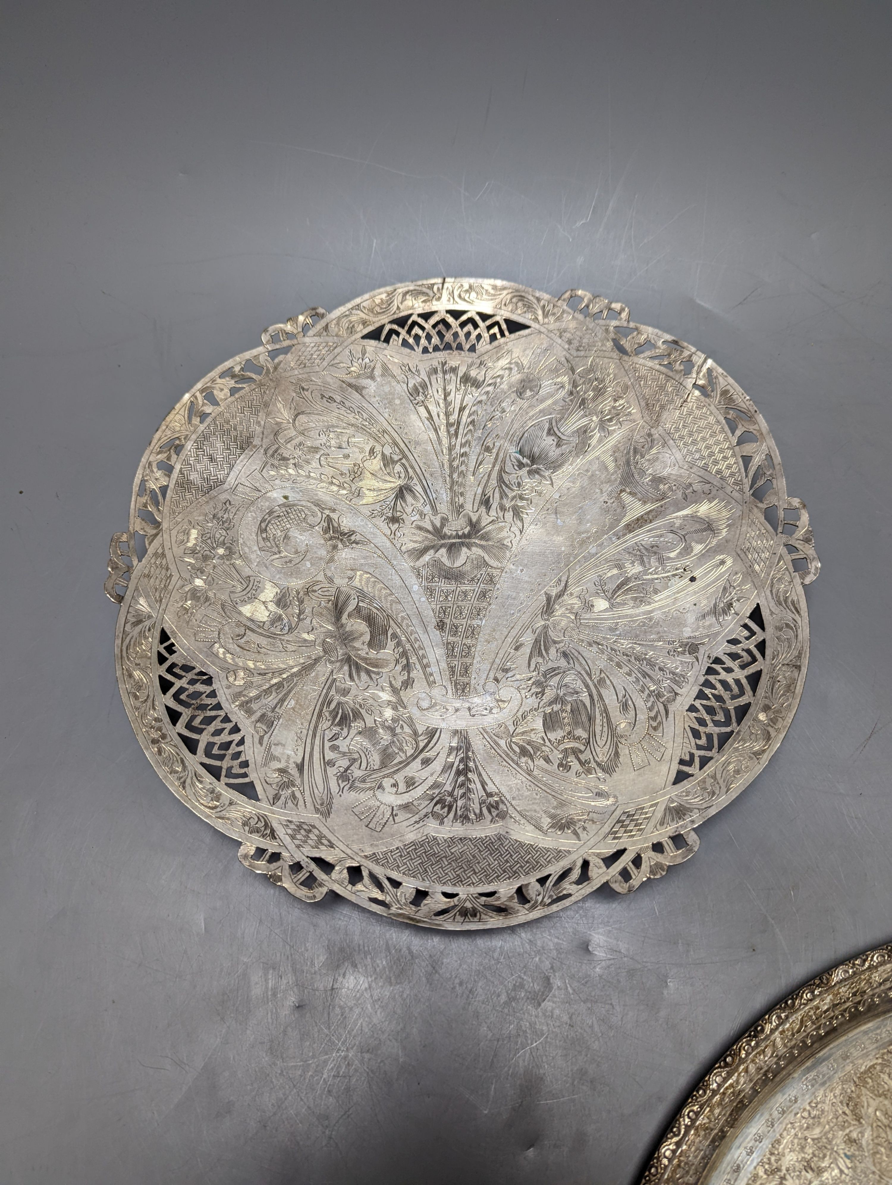 A Persian engraved white metal circular drink's tray by Vartan, 32cm, 747 grams and a white metal wall plaque.